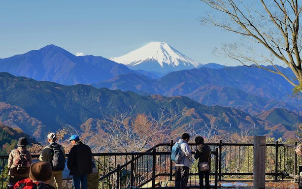 Hikers enjoying the view of Mount Fuji from Mount Takao near Tokyo.