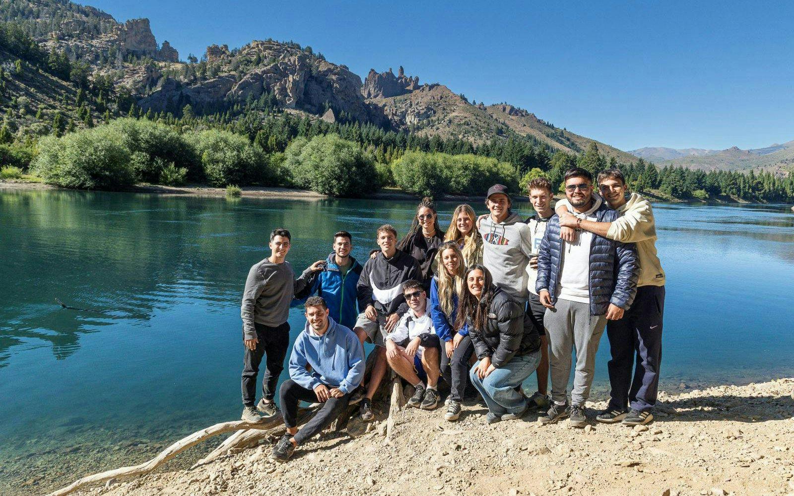 Tour group by a lake with mountain backdrop in Patagonia.