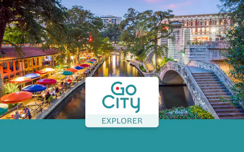 San Antonio River Walk with colorful umbrellas and stone bridge, Go City Explorer Pass.