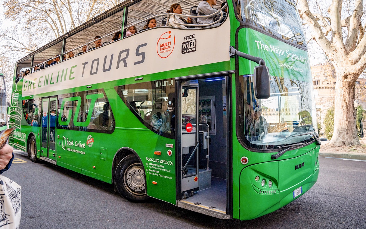 Green Line hop-on hop-off bus in Rome with passengers on the upper deck.