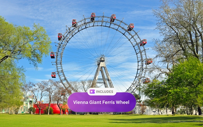 Vienna Giant Ferris Wheel in a park setting with trees and blue sky.