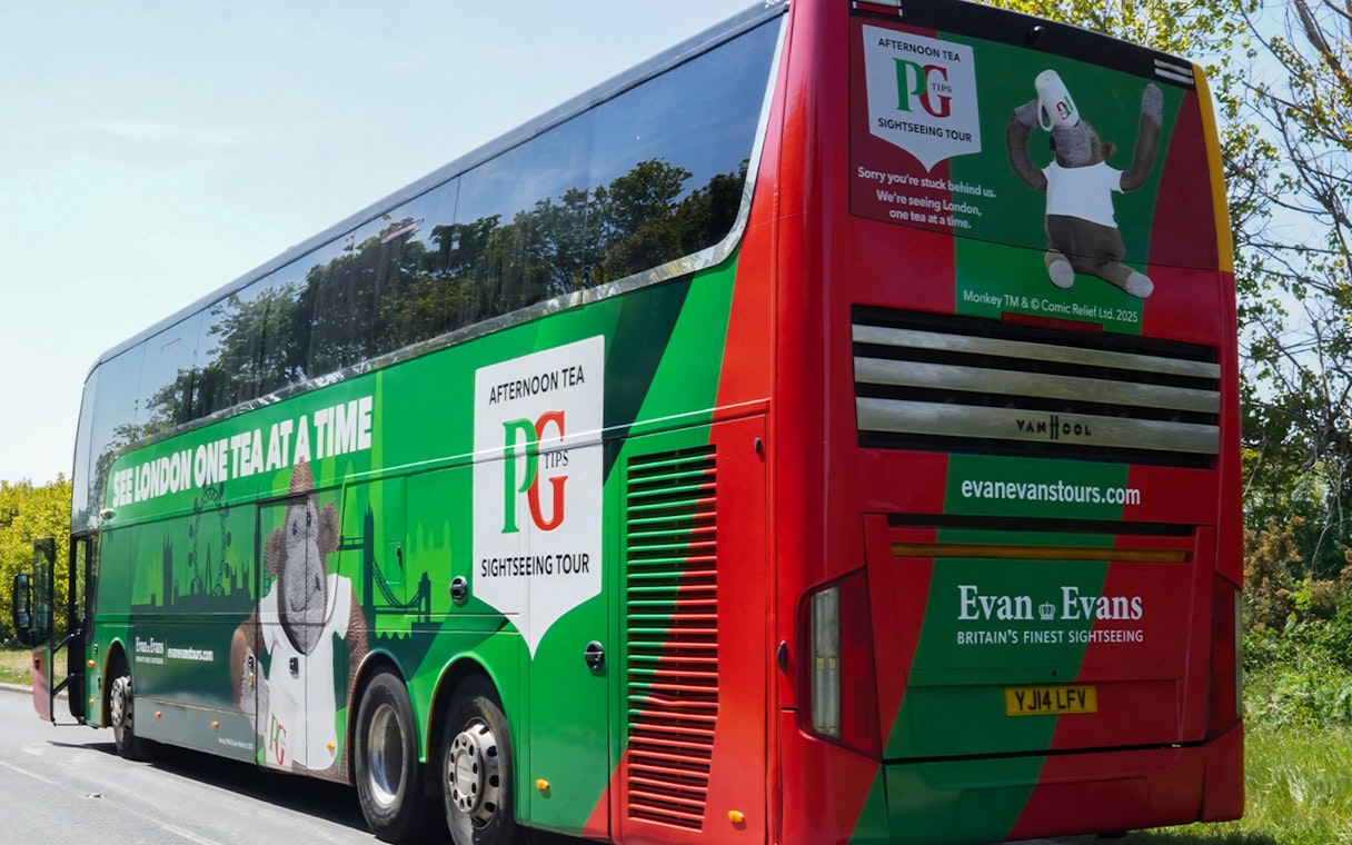 Afternoon Tea Bus with PG Tips branding on a scenic London road.