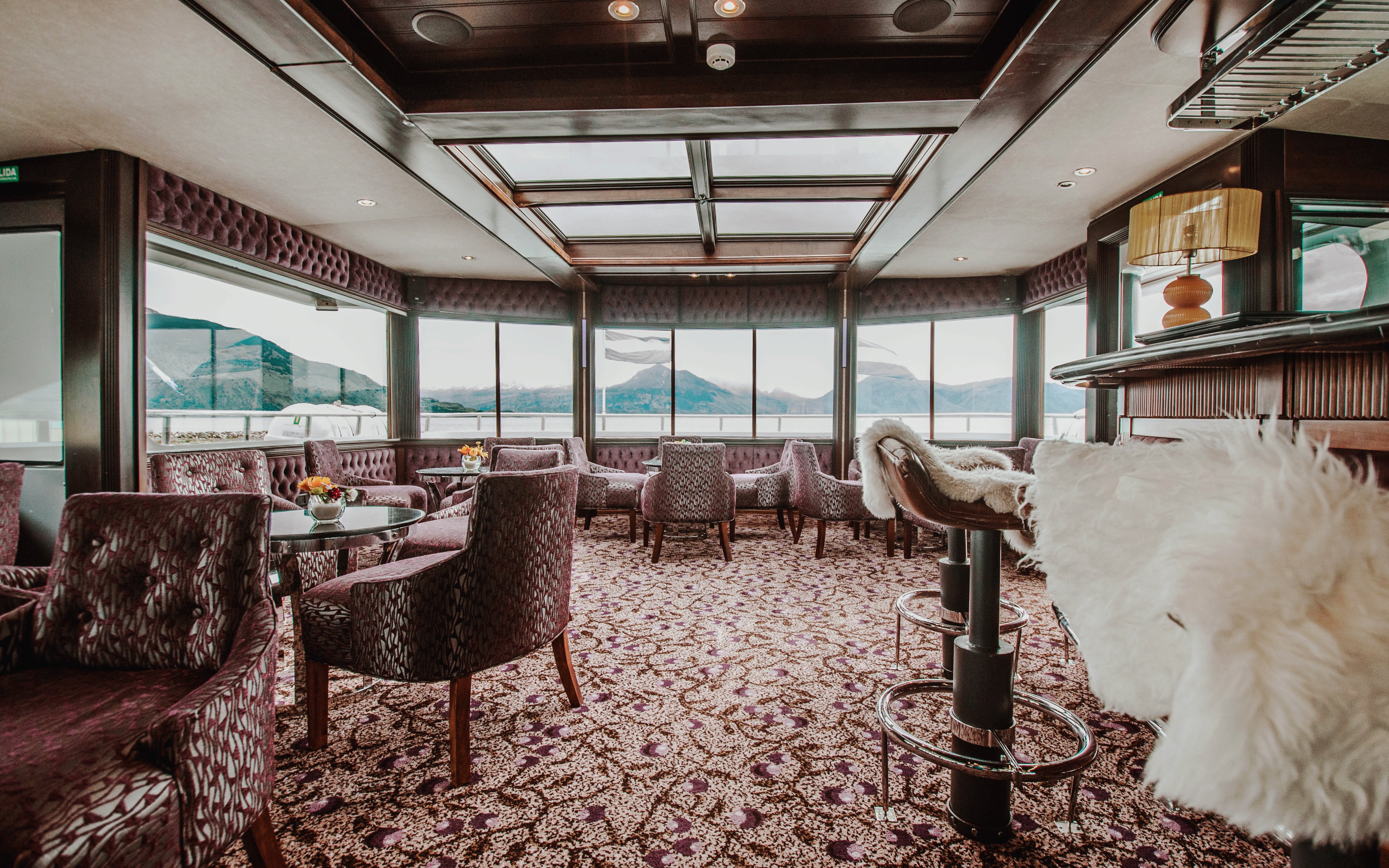 Luxurious boat interior with panoramic windows overlooking Upsala Glacier during Spirit of the Glaciers tour.