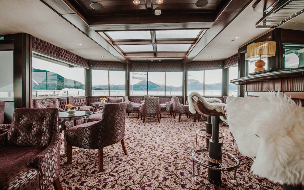 Luxurious boat interior with panoramic windows overlooking Upsala Glacier during Spirit of the Glaciers tour.