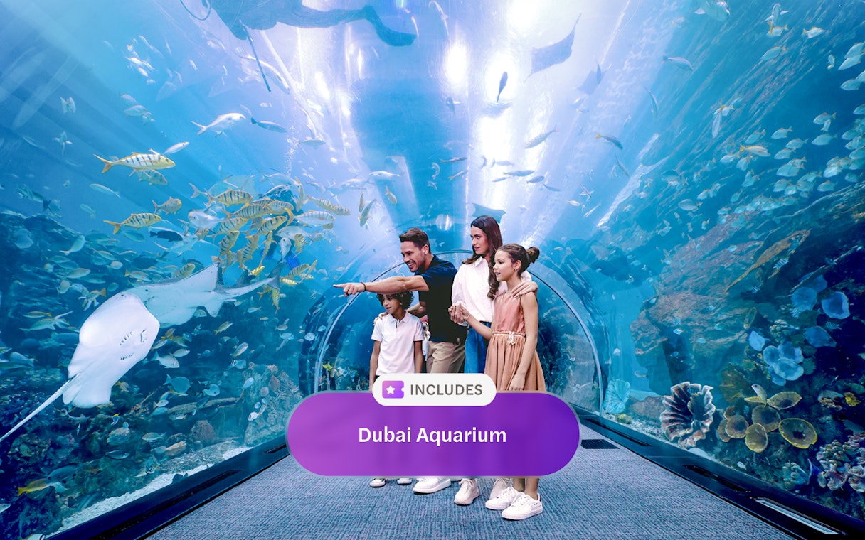 Family exploring underwater tunnel at Dubai Aquarium.