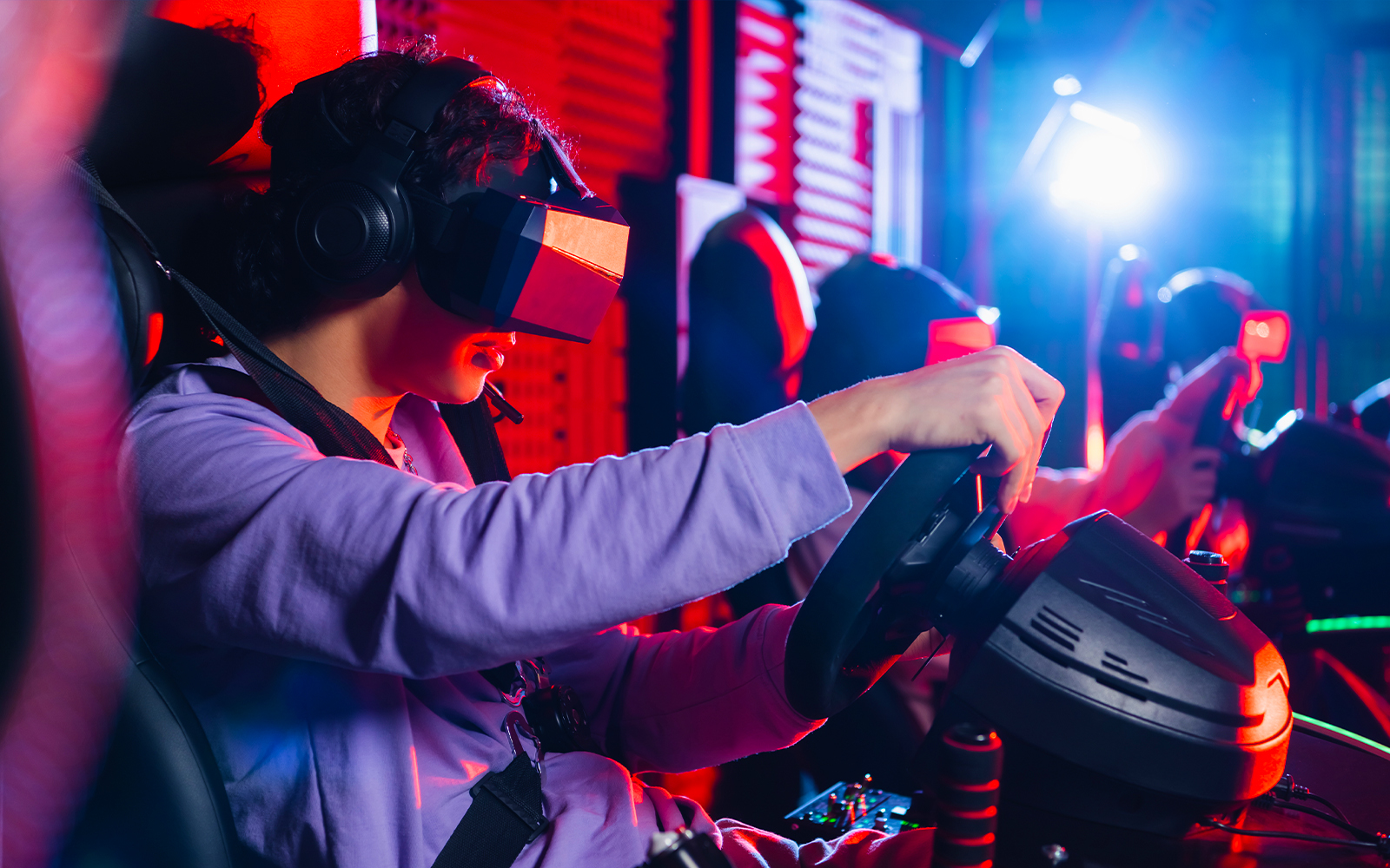 Person using a virtual reality headset in a Ferrari driving simulator.