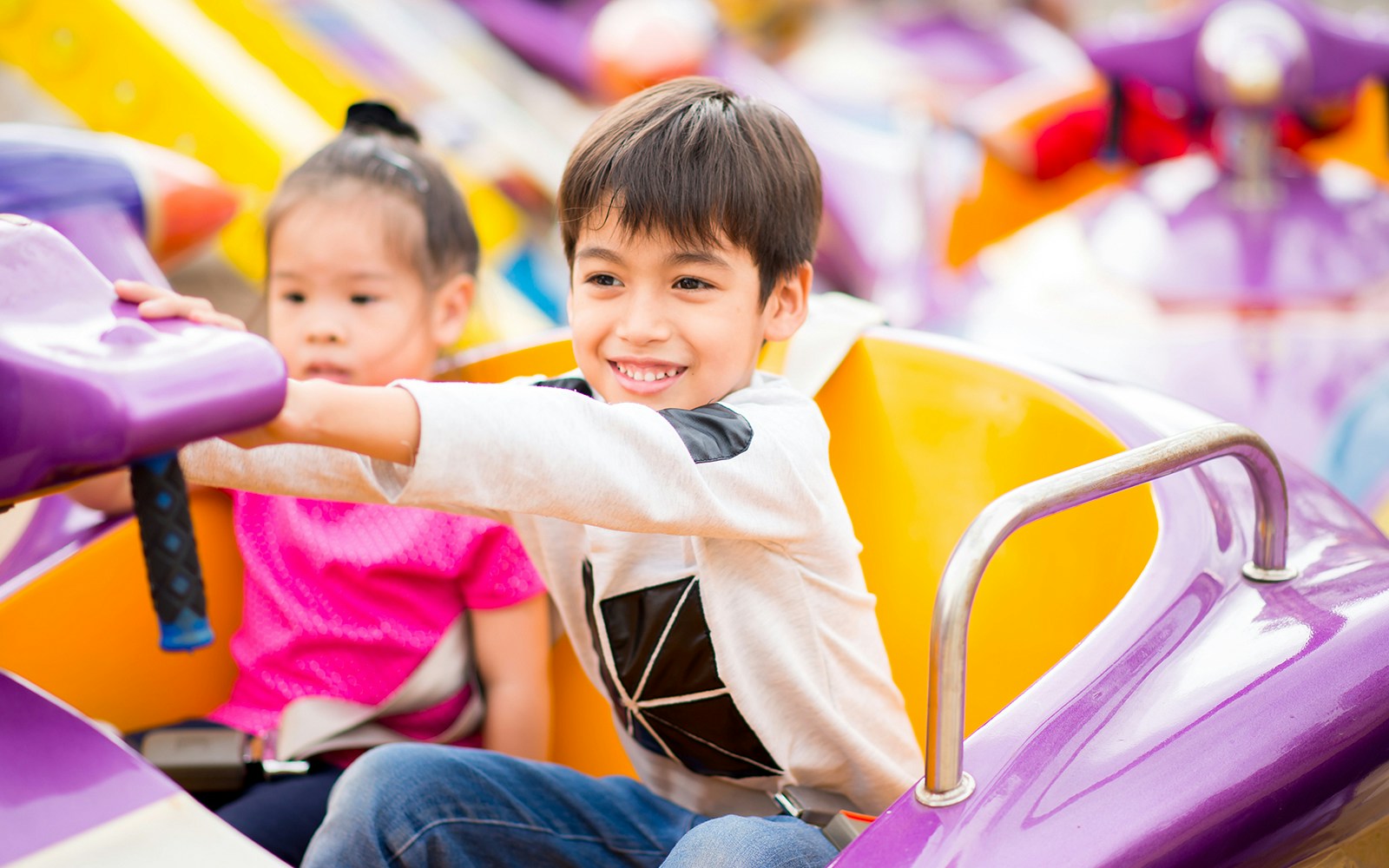 Children enjoying a colorful amusement park ride.