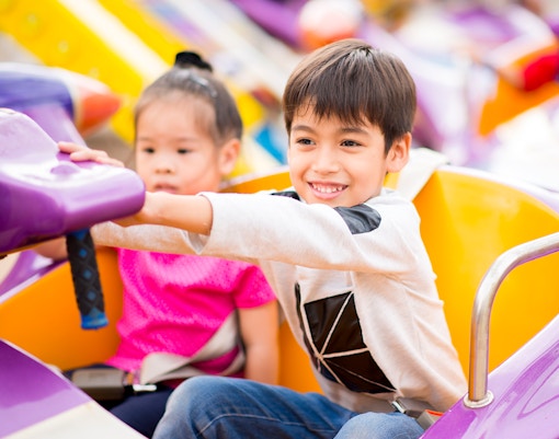 Children enjoying a spinning ride at an amusement park in Tokyo, Japan.