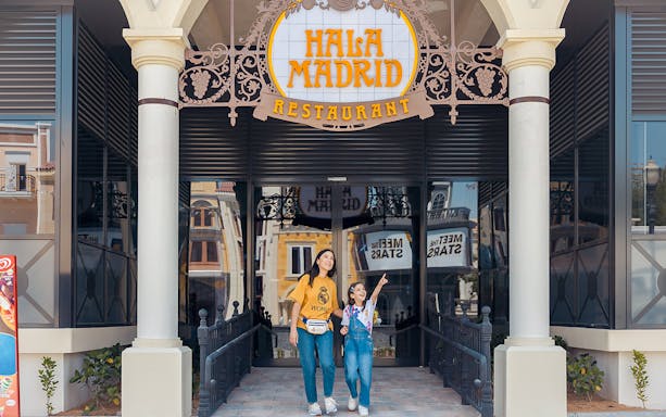 Mother and daughter entering Hala Madrid restaurant.