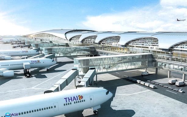Suvarnabhumi Airport terminal with Thai Airways planes at gates, Bangkok.