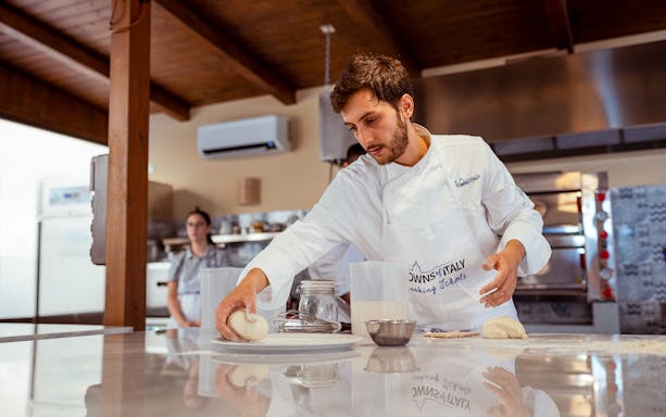 Chef preparing dough in a Palermo cooking class kitchen.