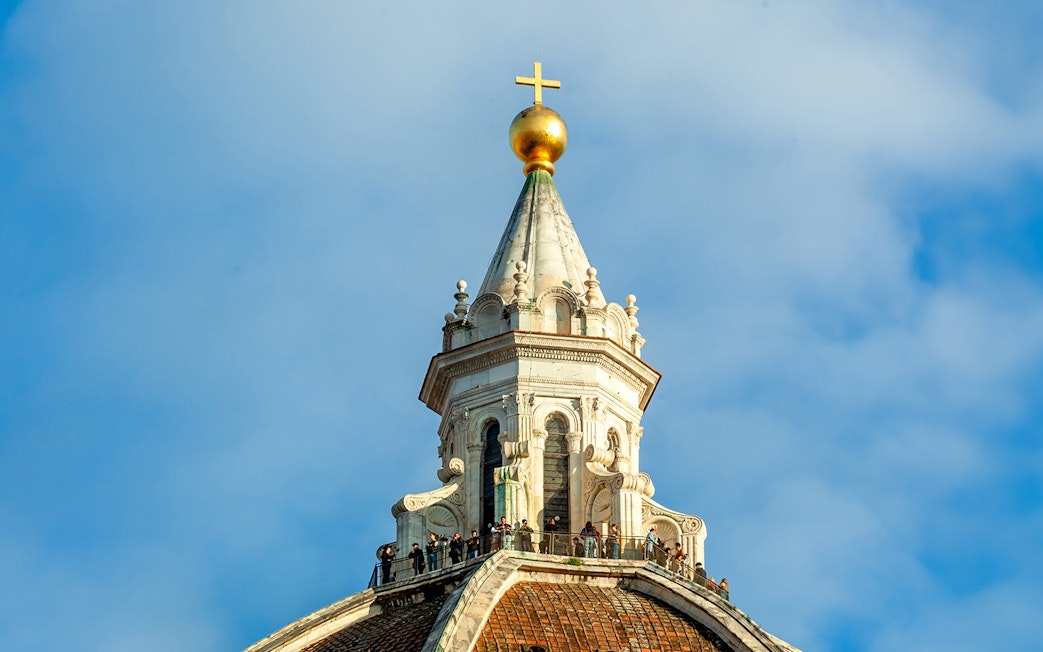 Dome details of Florence Cathedral with cross and observation deck.