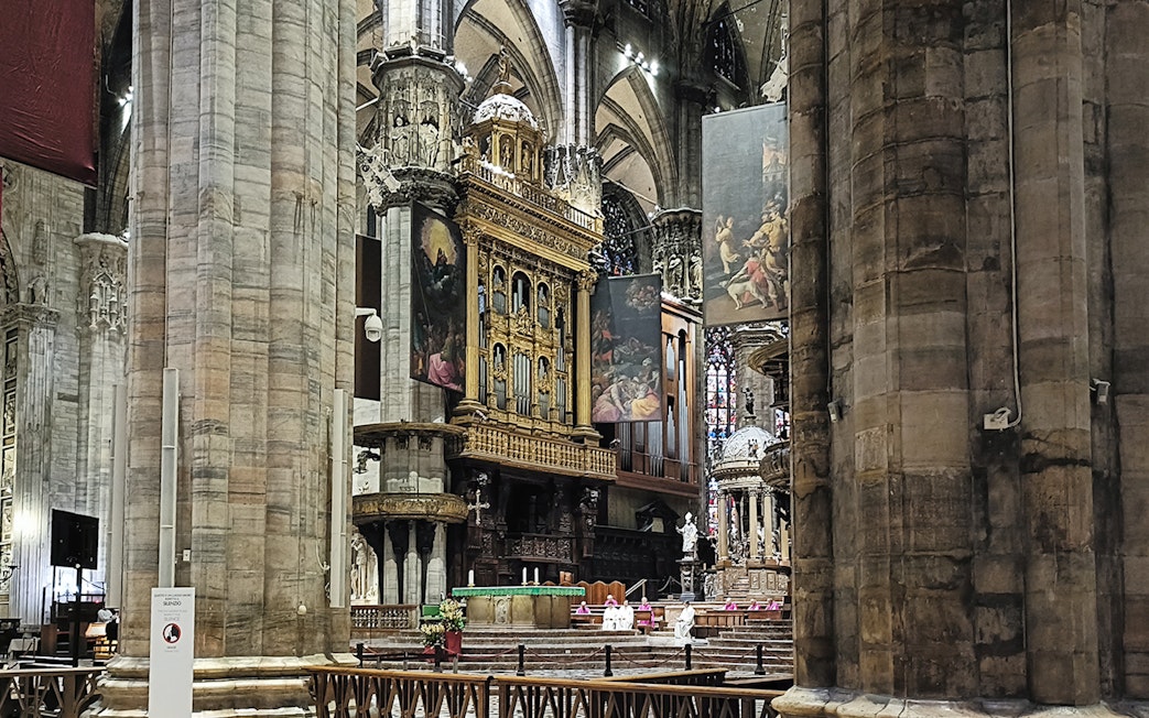 Interior view of Milan Cathedral's ornate altar and columns.