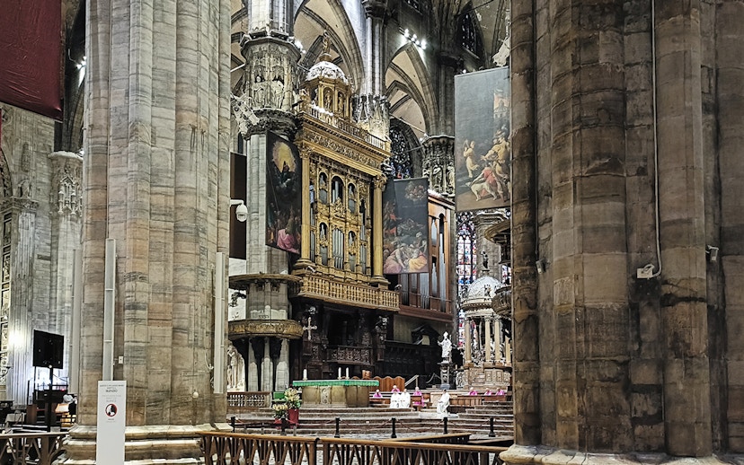 Interior view of Milan Cathedral's ornate altar and columns.