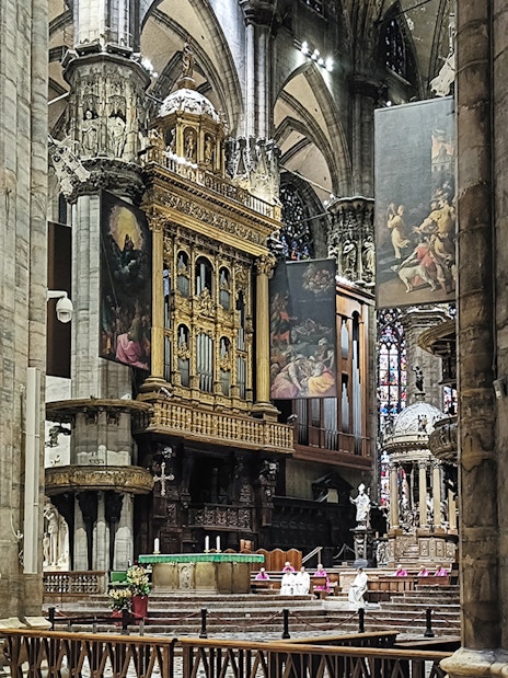 Interior view of Milan Cathedral's ornate altar and columns.