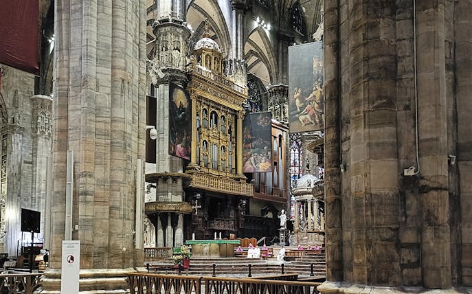 Interior view of Milan Cathedral's ornate altar and columns.
