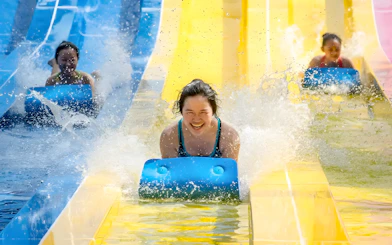 Water slides at Escape Penang water park with people enjoying the ride.