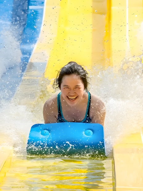 Water slides at Escape Penang water park with people enjoying the ride.
