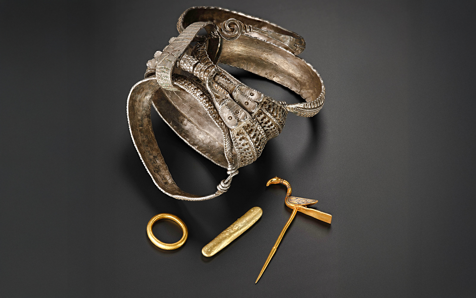 Viking Age silver arm rings, gold ring, ingot, and bird-shaped pin.