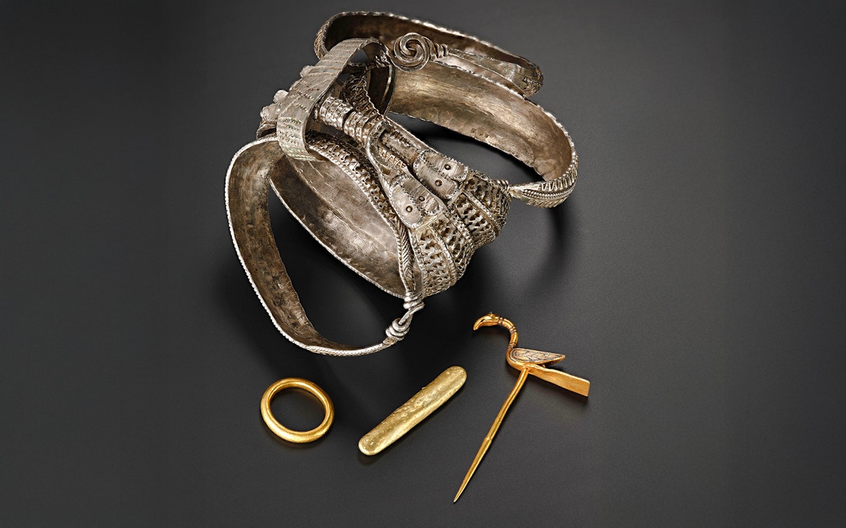 Viking Age silver arm rings, gold ring, ingot, and bird-shaped pin.