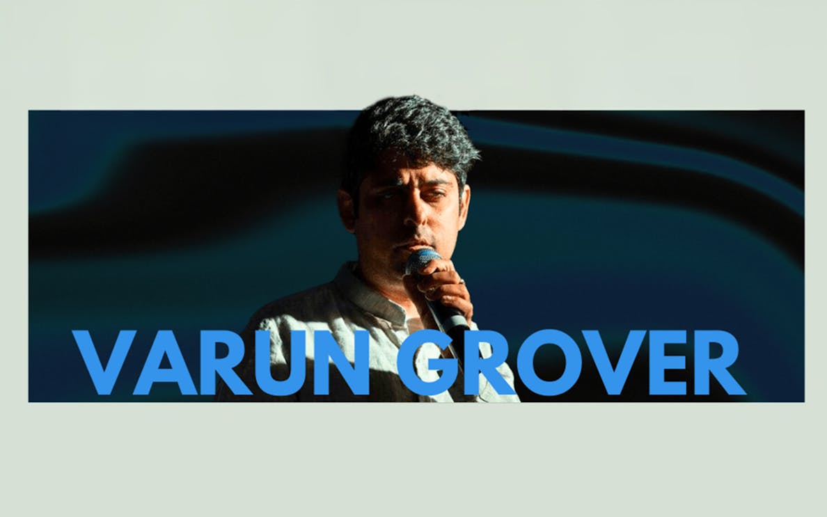 Varun Grover performing live with a microphone in Dubai.