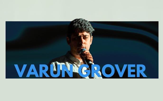 Varun Grover performing live with a microphone in Dubai.