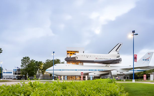 Airplanes displayed outside Houston Space Center, showcasing aviation history.