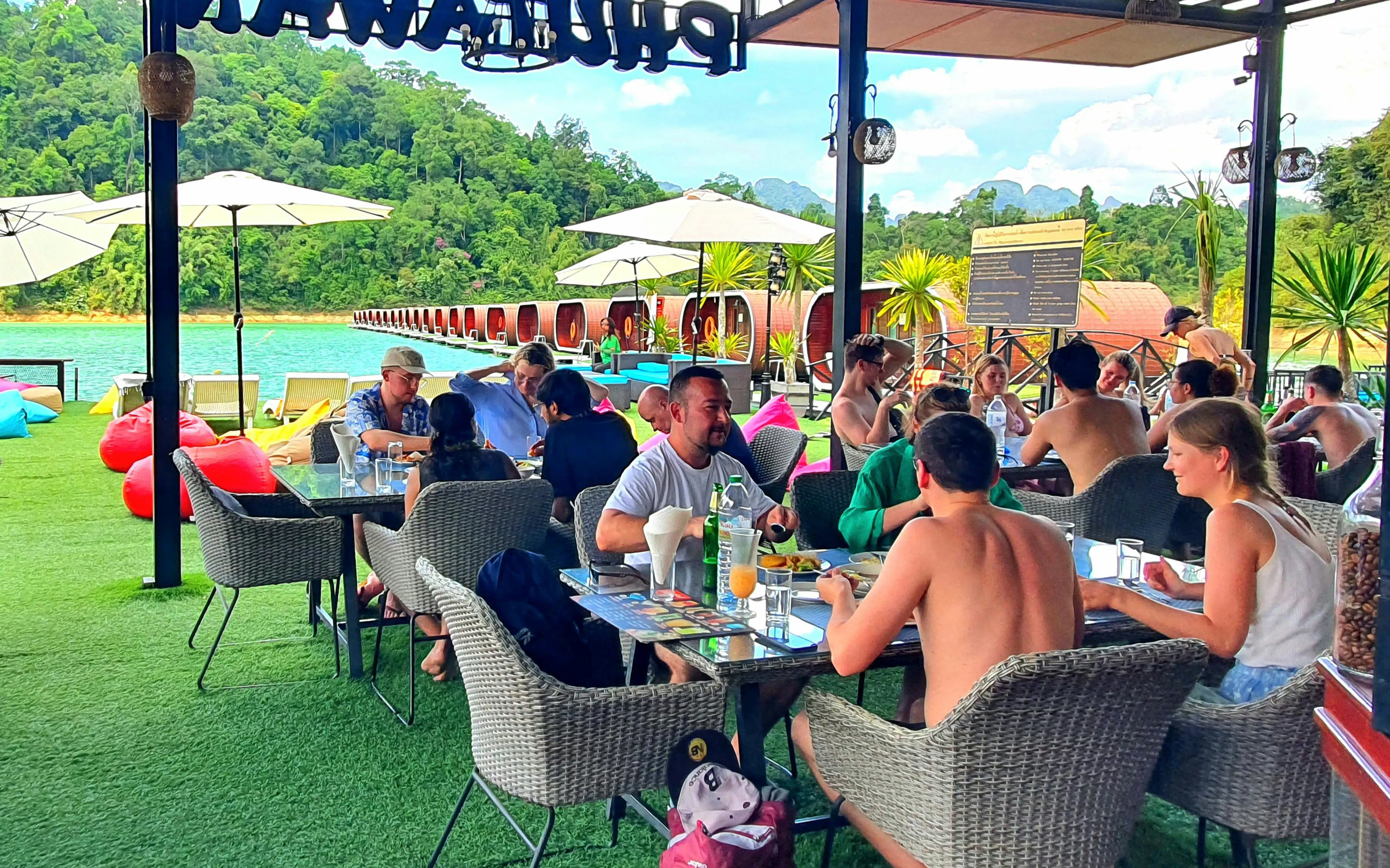 Tourists dining at a lakeside restaurant with views of Cheow Lan Lake, Krabi.