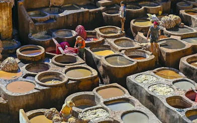 Tannery workers in Fes, Morocco, dyeing leather in stone vats.