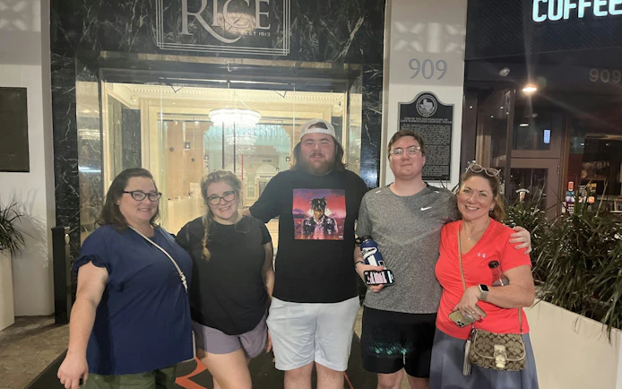 Group of people outside the historic Rice Hotel in Houston during a self-guided city exploration game.