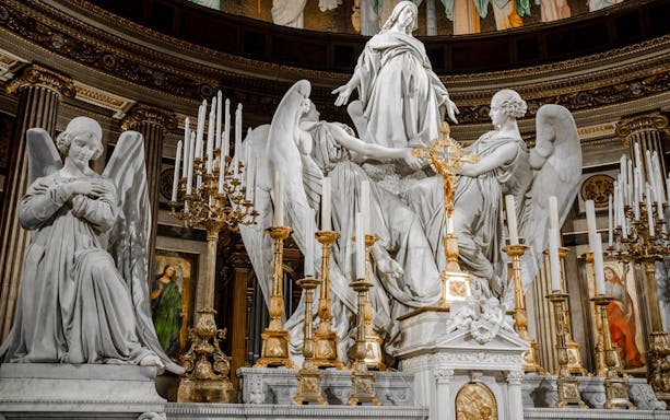 Statues and ornate altar inside The Church of St Madeleine, Paris, France.