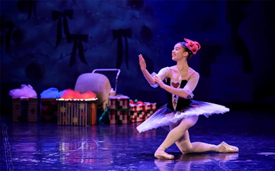 Ballerina performing at a gala in Prague's Old Town with stage props in the background.