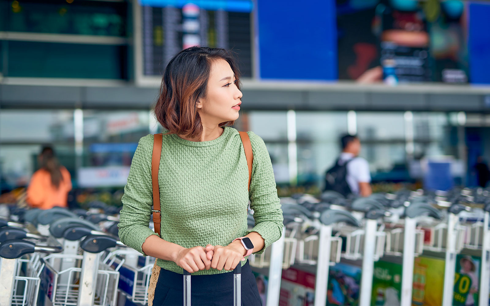Traveler waiting with luggage at Istanbul Airport shuttle bus area.