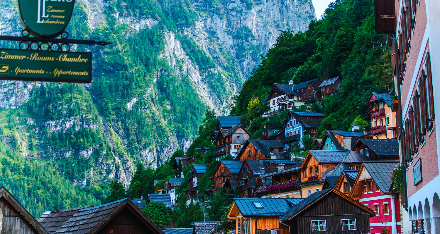 Colorful hillside houses in Hallstatt with mountain backdrop, part of Vienna day trip tour.