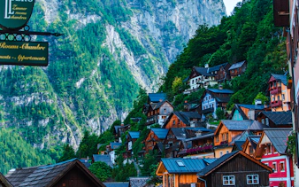 Colorful hillside houses in Hallstatt with mountain backdrop, part of Vienna day trip tour.