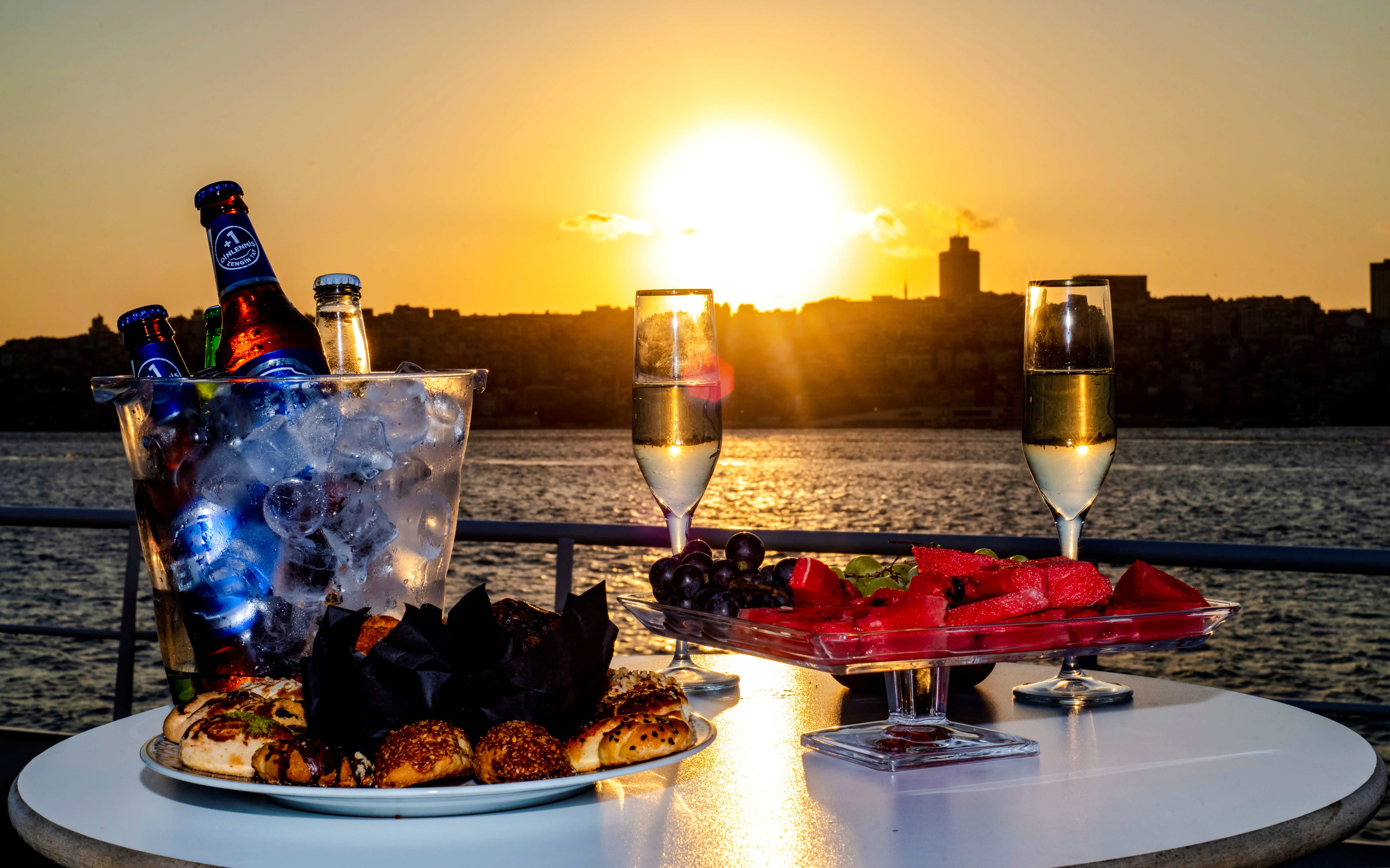Champagne and snacks on a table during a Bosphorus lunch cruise at sunset.