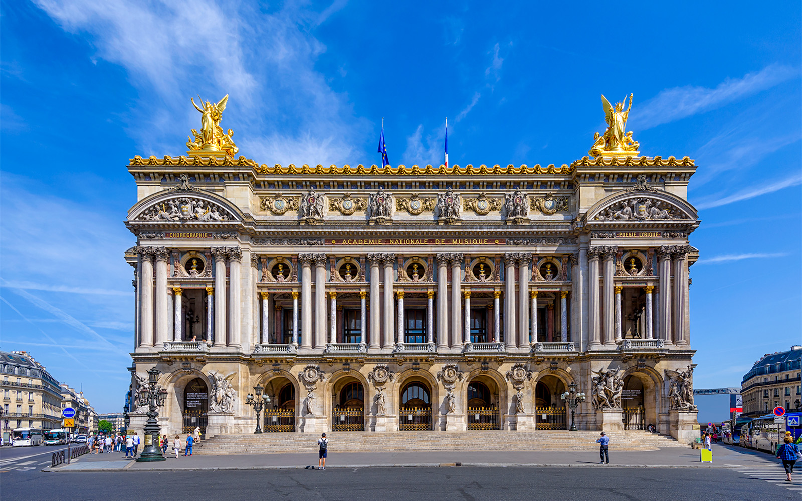 Opera Garnier facade in Paris with visitors exploring the entrance.