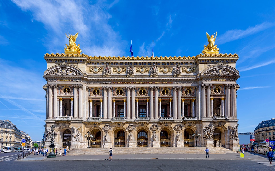 Opera Garnier facade in Paris with visitors exploring the entrance.