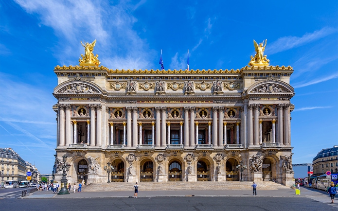Opera Garnier facade in Paris with visitors exploring the entrance.