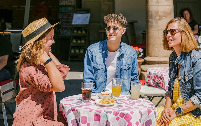 Visitors enjoying drinks at an outdoor café in Poble Espanyol, Barcelona.
