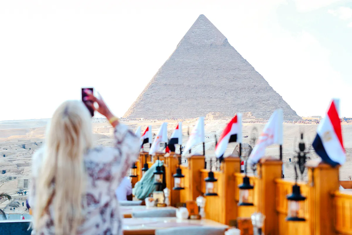 Rooftop dining with view of Giza Pyramid, flags lining the terrace, Giza, Egypt.