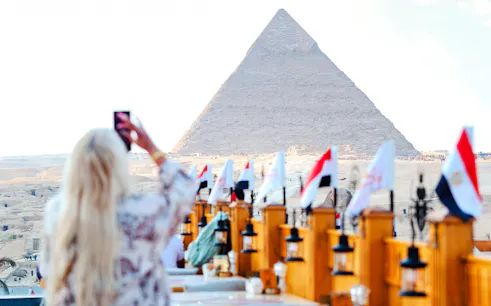 Rooftop dining with view of Giza Pyramid, flags lining the terrace, Giza, Egypt.