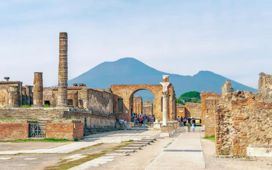 Ancient ruins of Pompeii with Mount Vesuvius in the background.