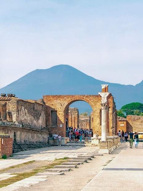 Ancient ruins of Pompeii with Mount Vesuvius in the background.