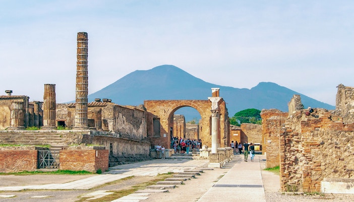 Ancient ruins of Pompeii with Mount Vesuvius in the background, part of a half-day guided tour from Naples.