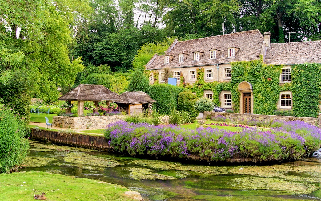 Cotswolds village house with ivy, garden, and stream on small group tour.