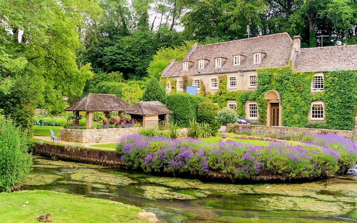 Cotswolds village house with ivy, garden, and stream on small group tour.