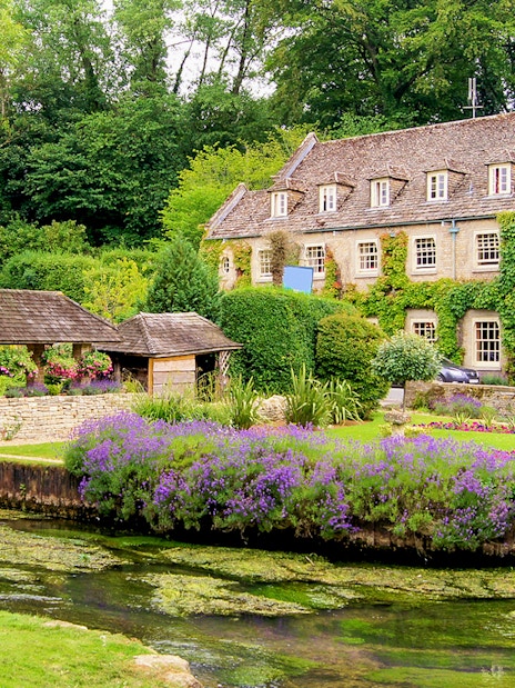 Cotswolds village house with ivy, garden, and stream on small group tour.
