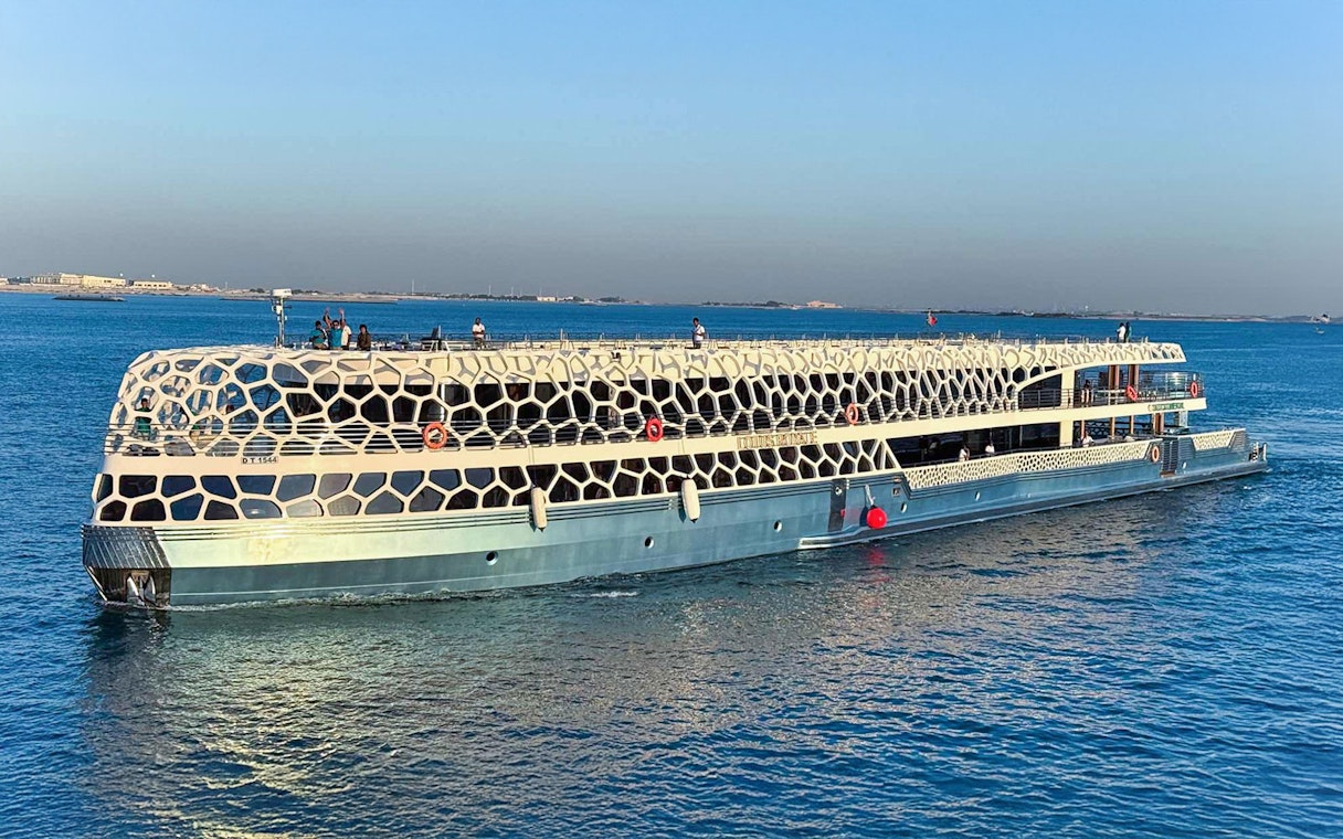 Lotus Mega Yacht cruising in Dubai Marina with guests on deck.