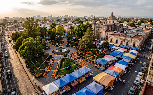 Plaza with colorful market stalls and Day of the Dead decorations, Mexico City.